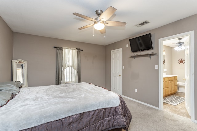 bedroom featuring ceiling fan, light carpet, and ensuite bathroom