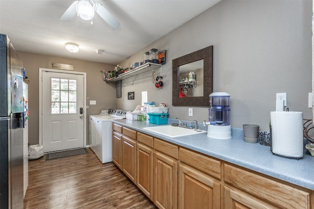 kitchen with dark wood-type flooring, sink, stainless steel refrigerator, separate washer and dryer, and ceiling fan