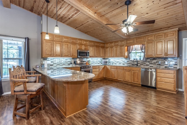 kitchen with appliances with stainless steel finishes, a kitchen breakfast bar, backsplash, kitchen peninsula, and ceiling fan