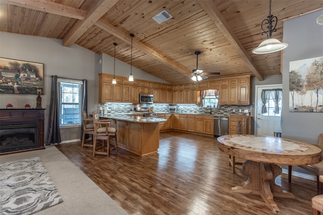 kitchen with hanging light fixtures, dark wood-type flooring, stainless steel appliances, ceiling fan, and sink