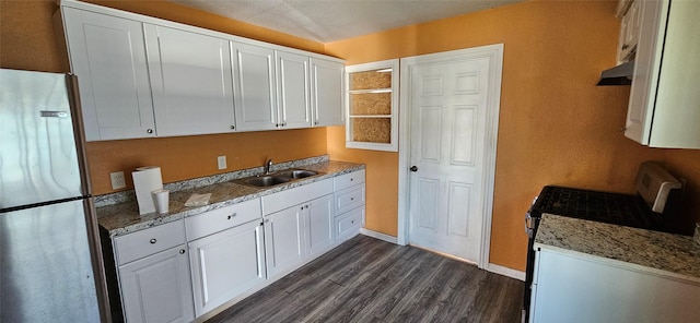 kitchen with white cabinets, sink, stainless steel refrigerator, and white stove