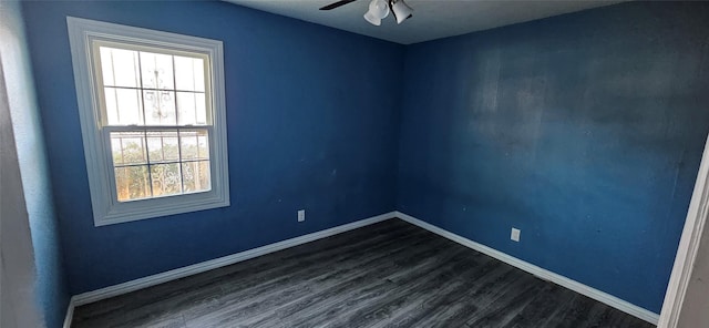 spare room with dark wood-type flooring, baseboards, and ceiling fan