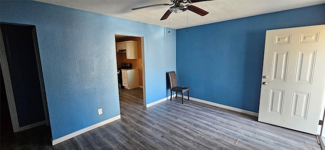 unfurnished room with baseboards, a textured wall, a textured ceiling, ceiling fan, and wood finished floors