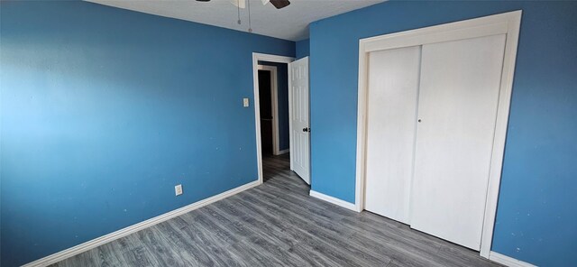 unfurnished bedroom with ceiling fan, a closet, and wood-type flooring