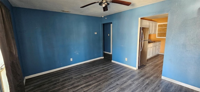 unfurnished bedroom featuring ensuite bathroom, ceiling fan, stainless steel fridge, a textured ceiling, and dark hardwood / wood-style flooring