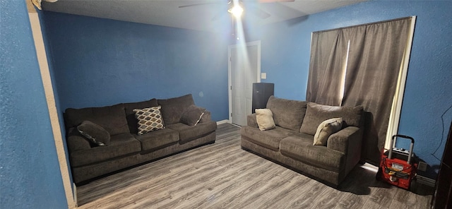 living room with wood-type flooring and ceiling fan