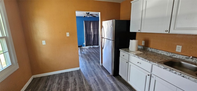 kitchen with baseboards, white cabinets, dark wood-style flooring, a sink, and ceiling fan