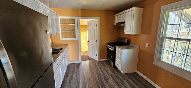 kitchen with white cabinetry, dark wood-type flooring, light stone countertops, and appliances with stainless steel finishes