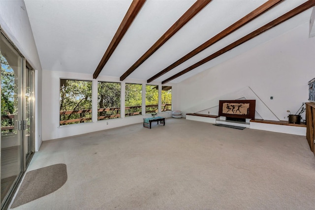 unfurnished living room with carpet flooring and lofted ceiling with beams