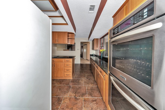 kitchen featuring a textured ceiling and stainless steel double oven