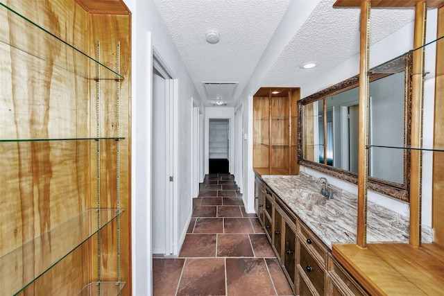 corridor featuring sink and a textured ceiling