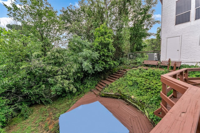 view of yard with central AC unit and a wooden deck