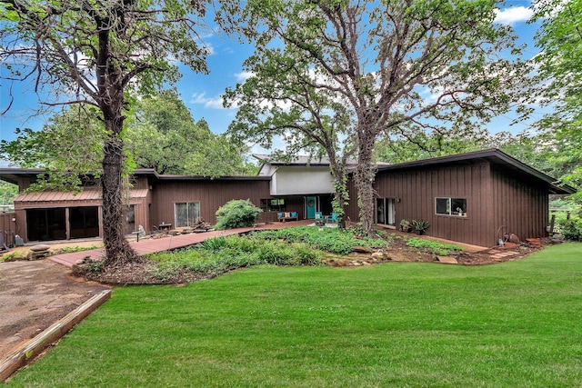 rear view of property with a lawn