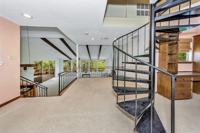 staircase with lofted ceiling, a textured ceiling, carpet floors, and a healthy amount of sunlight