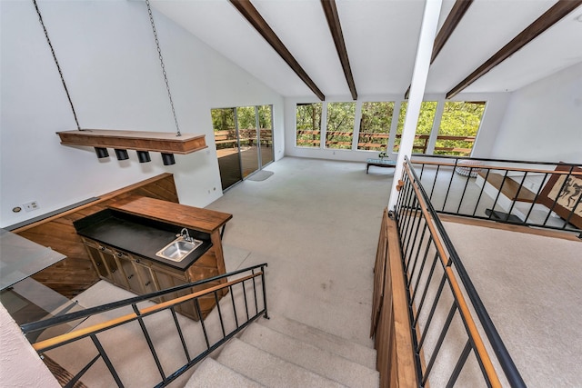 stairway featuring carpet and vaulted ceiling with beams