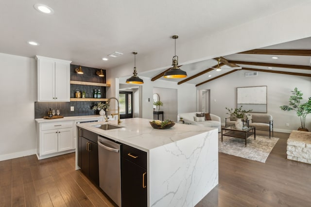 kitchen with dishwasher, a kitchen island with sink, sink, white cabinetry, and vaulted ceiling with beams