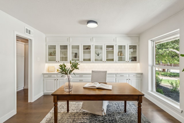 home office featuring a textured ceiling and dark hardwood / wood-style flooring