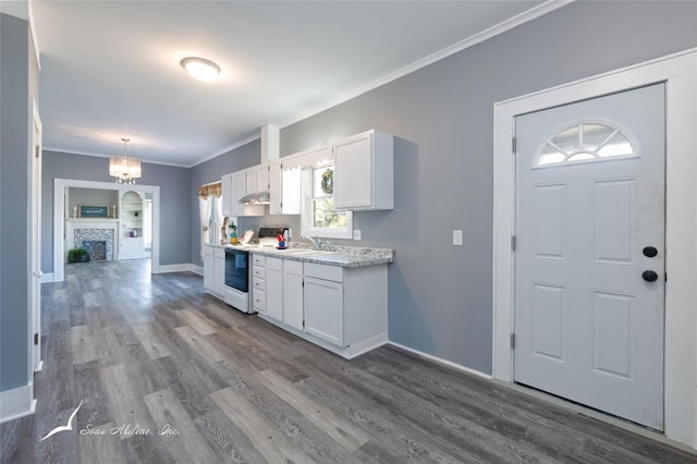 kitchen with ornamental molding, dark wood-type flooring, under cabinet range hood, white cabinetry, and white range with electric cooktop