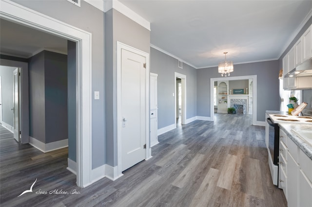 kitchen with white cabinetry, a notable chandelier, crown molding, white electric stove, and dark hardwood / wood-style flooring