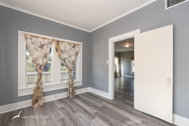 empty room with crown molding and hardwood / wood-style floors