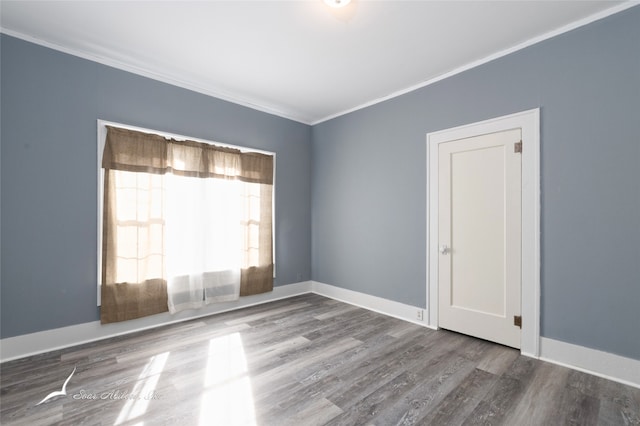 unfurnished room featuring hardwood / wood-style flooring and crown molding