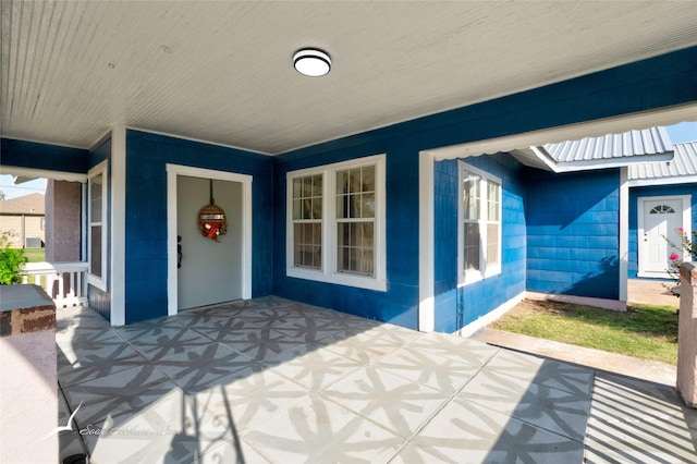 property entrance featuring covered porch and concrete block siding