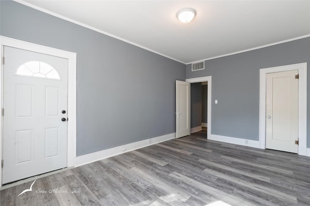 entryway featuring baseboards, visible vents, crown molding, and wood finished floors