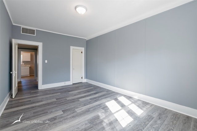 unfurnished bedroom featuring wood-type flooring and ornamental molding