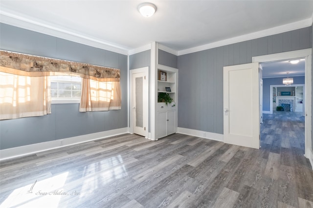 unfurnished room featuring wood-type flooring and ornamental molding