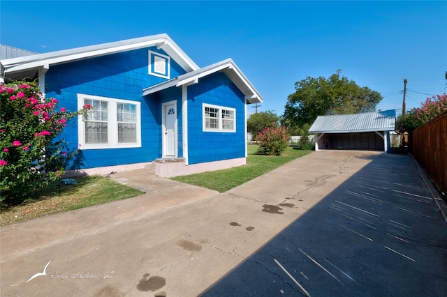 bungalow-style house with a front yard, a garage, and an outdoor structure