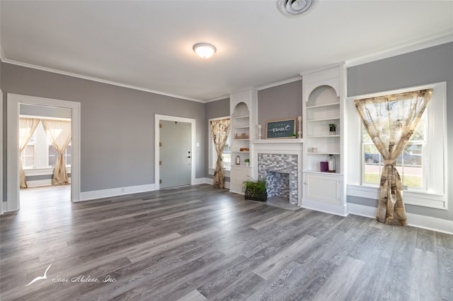 unfurnished living room with hardwood / wood-style flooring, a tile fireplace, ornamental molding, and a wealth of natural light