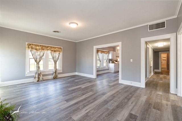 unfurnished room with ornamental molding, dark wood-type flooring, baseboards, and visible vents