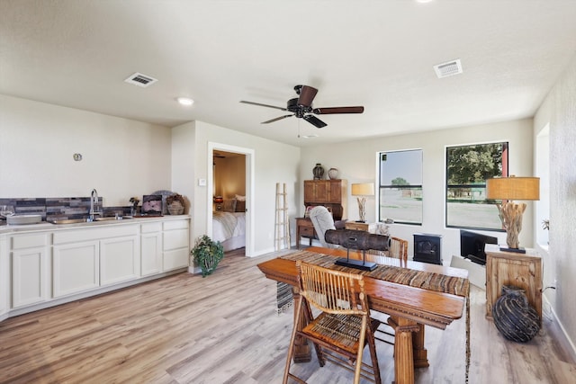 dining room with light hardwood / wood-style flooring, ceiling fan, and sink