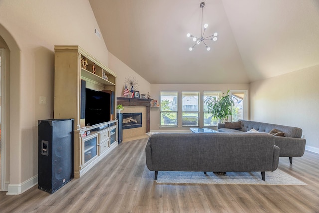 living room featuring light hardwood / wood-style flooring, a chandelier, and high vaulted ceiling