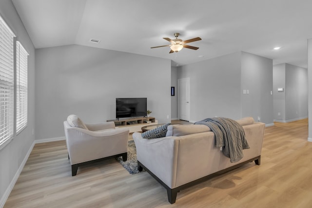 living room with light wood-type flooring, vaulted ceiling, and ceiling fan