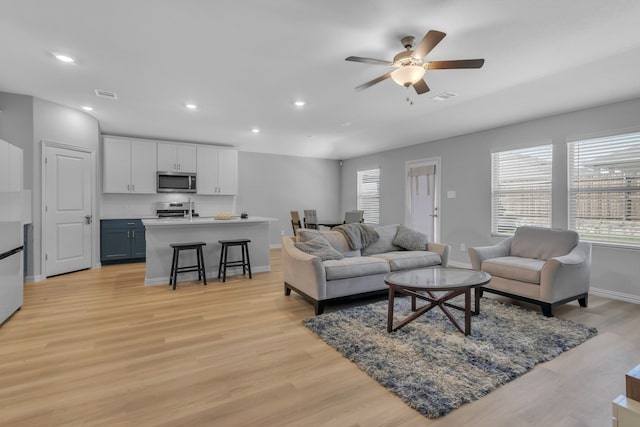 living room with ceiling fan and light hardwood / wood-style floors