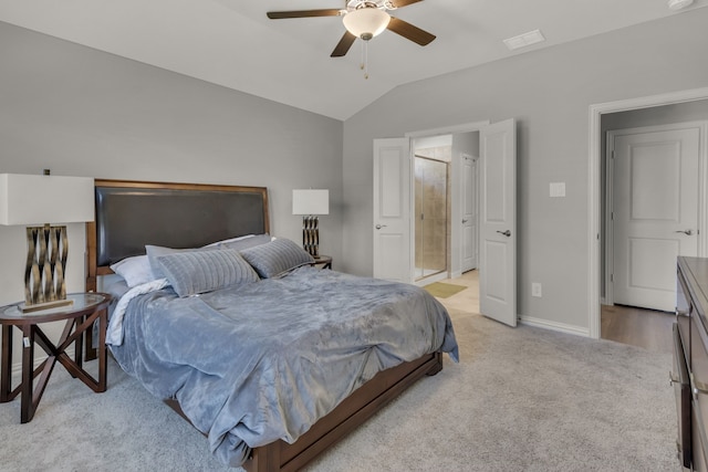 bedroom featuring connected bathroom, vaulted ceiling, ceiling fan, and light colored carpet