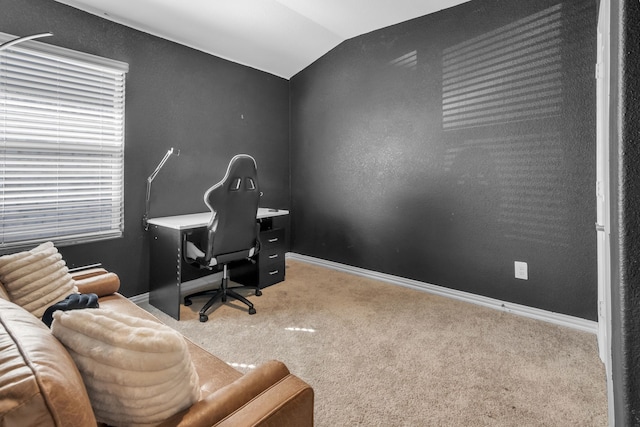 carpeted home office featuring vaulted ceiling