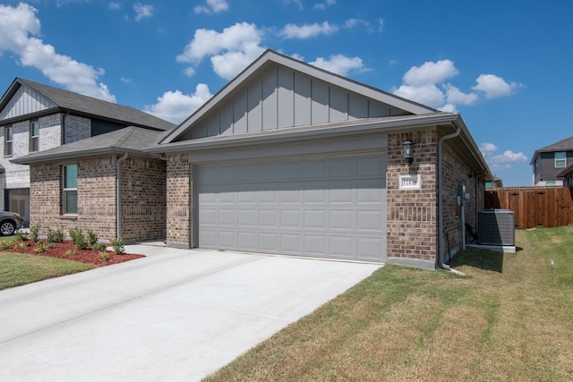 view of front facade featuring a front lawn, central AC unit, and a garage