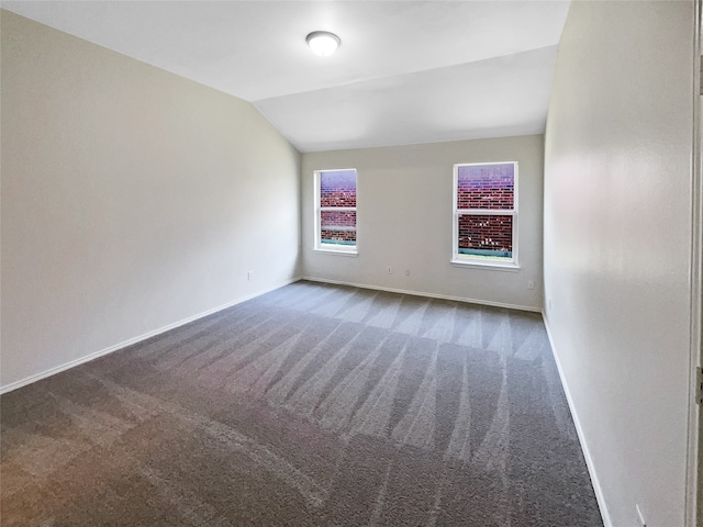 spare room with carpet and lofted ceiling