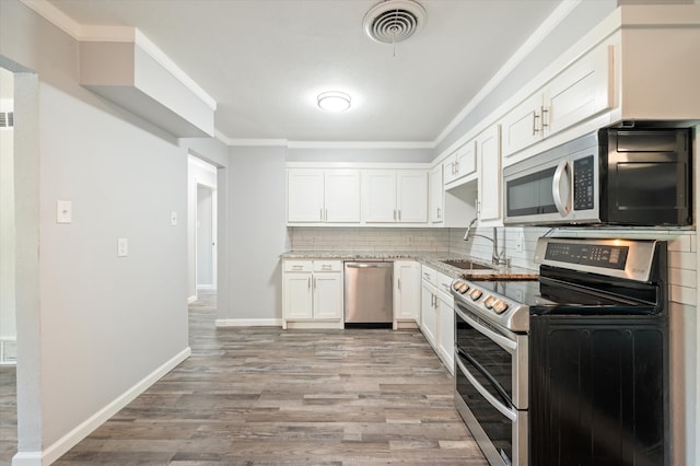 kitchen featuring light hardwood / wood-style floors, sink, white cabinets, stainless steel appliances, and backsplash