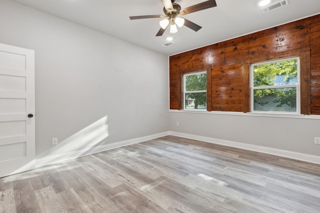 empty room featuring light hardwood / wood-style flooring, a wealth of natural light, and ceiling fan