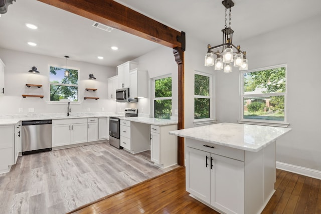 kitchen with light hardwood / wood-style floors, white cabinetry, and stainless steel appliances