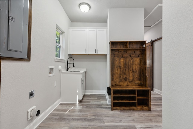 washroom featuring cabinets, sink, hardwood / wood-style flooring, a barn door, and hookup for an electric dryer