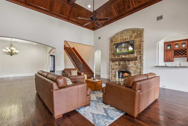 living room featuring wood ceiling, a stone fireplace, ceiling fan with notable chandelier, and high vaulted ceiling