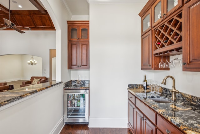 kitchen featuring dark stone counters, wine cooler, sink, hanging light fixtures, and dark hardwood / wood-style flooring