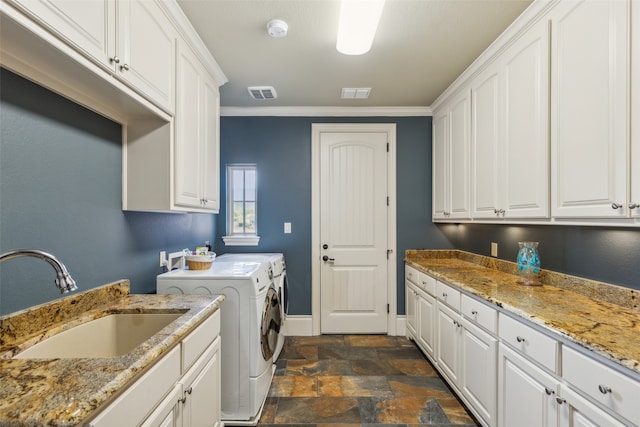 laundry room featuring cabinets, crown molding, washer and dryer, and sink