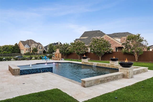 view of swimming pool with pool water feature, a patio, and a yard