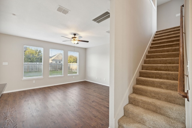 stairway featuring wood-type flooring and ceiling fan