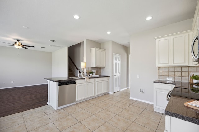 kitchen with backsplash, white cabinets, light hardwood / wood-style flooring, stainless steel dishwasher, and kitchen peninsula